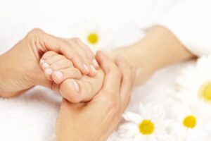 Massage therapist performing foot massage